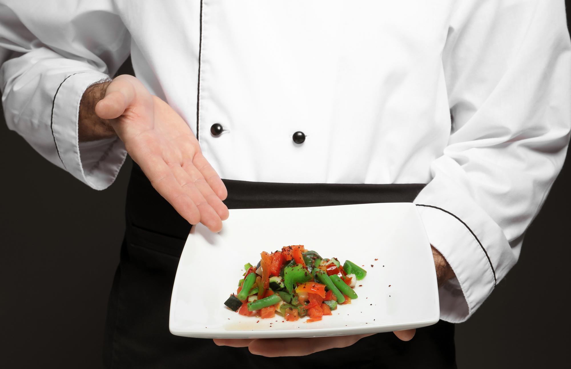 Instructor demonstrating plated dish in kitchen studio